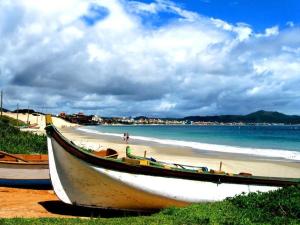 um barco sentado na costa de uma praia em Condomínio frente mar na Praia dos Ingleses - HB08F em Florianópolis