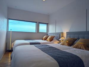 sypialnia z 2 łóżkami i dużym oknem w obiekcie One House Naganuma MAOI - Vacation STAY 09878v w mieście Naganuma