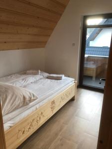ein großes Bett in einem Zimmer mit Fenster in der Unterkunft Domki nad potokiem in Białka Tatrzańska
