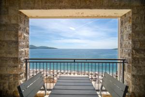 a room with a view of the ocean from a balcony at Lustica Bay Marina Village by 2BHome in Lustica