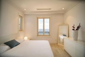 a white bedroom with a large bed and a window at Lustica Bay Marina Village by 2BHome in Lustica