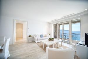 a living room with a white couch and a table at Lustica Bay Marina Village by 2BHome in Lustica