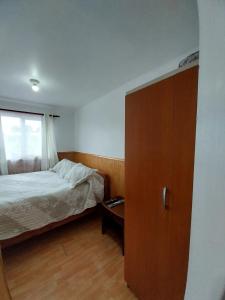 1 dormitorio con 1 cama, vestidor y ventana en ACOGEDOR DEPARTAMENTO, en Puerto Montt