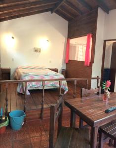 1 dormitorio con cama y mesa de madera en Cabañas Mar Azul en Balneario Mar Azul