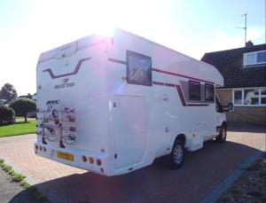 a white camper truck parked in front of a house at RollerTeam Zafiro 685 - 5 Berth Motorhome in Kirton