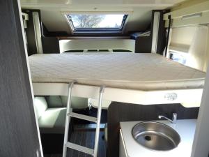 a bed and a sink in an rv at RollerTeam Zafiro 685 - 5 Berth Motorhome in Kirton