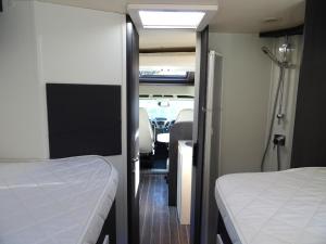 a room with two beds and a tv in an rv at RollerTeam Zafiro 685 - 5 Berth Motorhome in Kirton