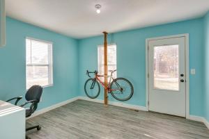 a room with blue walls and a bike hanging on the wall at Charming Missouri Home Less Than 1 Mi to Katy Trail! in Pleasant Hill