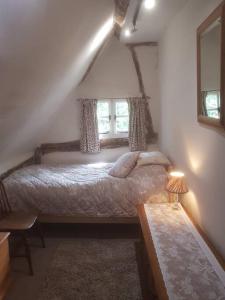 a bedroom with a bed and a window at Delightful 3bed thatched Cottage in Stockbridge