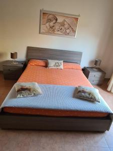 a bedroom with a large bed with two pillows at Charme in Aci Castello in Aci Castello