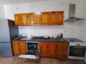 a kitchen with wooden cabinets and a sink and a refrigerator at Dolce Dimora in Cascia