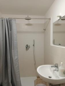 a white bathroom with a shower and a sink at Dolce Dimora in Cascia
