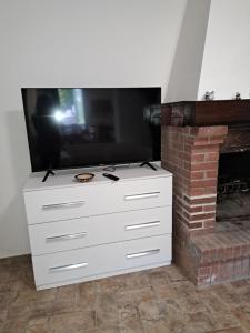 a tv on top of a dresser with a fireplace at Dolce Dimora in Cascia