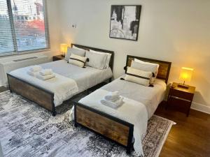 a bedroom with two beds and a table in it at Comfy Getaway by DC,Metro,Airport in Arlington