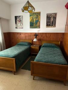 タンディルにあるCasa con piletaのベッド2台(壁にポスター付)が備わるベッドルーム1室