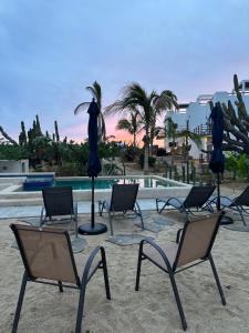 un grupo de sillas y sombrillas junto a una piscina en Villas Del Scarlet Cardones, en Pescadero