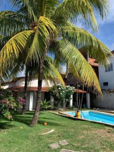 Casa de Veraneio com Piscina Perto da Praia في لورو دي فريتاس: نخلة بجانب منزل به مسبح
