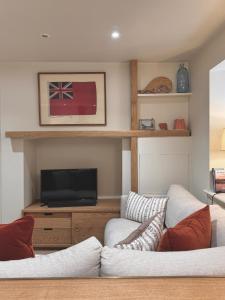 a living room with two couches and a tv at Y Cwtch Cottage By Birch Stays in Rhosneigr