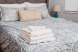 a pile of towels sitting on top of a bed at Outdoor Space - Parking - 1st Floor - Walkable in Pittsburgh