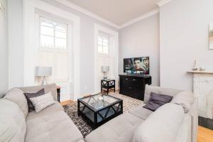 a white living room with a couch and a tv at Outdoor Space - Parking - 1st Floor - Walkable in Pittsburgh