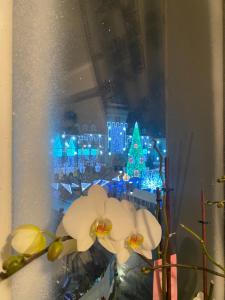 un vase avec des fleurs blanches devant un écran de christmas dans l'établissement Vintage Apartament Ultracentral, à Craiova