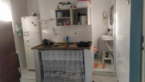 a small kitchen with a sink and a refrigerator at Familia Rodrigues in Guarujá