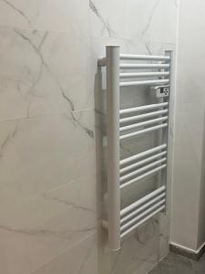 een badkamer met witte marmeren muren en een zilveren radiator bij CÔTÉ D’AZUR TOULON in Toulon