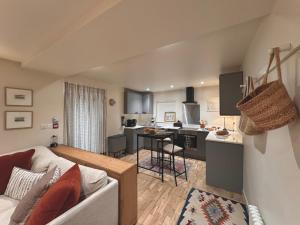 a living room with a couch and a kitchen at Y Cwtch Cottage by Birch Stays in Rhosneigr