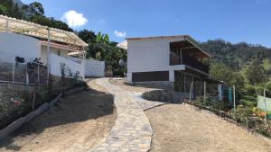 a building with a stone path next to a building at TARAHARA salud y bienestar in Santandercito