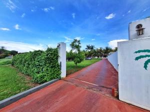 an entrance to a house with a red driveway at POUSADA POR DO SOL in Olímpia