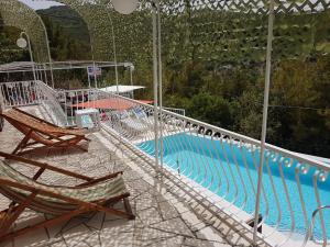 a swimming pool with two deck chairs next to it at Apartments Villa Sonia & Teo Hvar in Hvar
