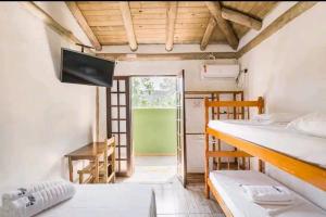 a room with two bunk beds and a balcony at Prumirim Surf Suítes in Ubatuba