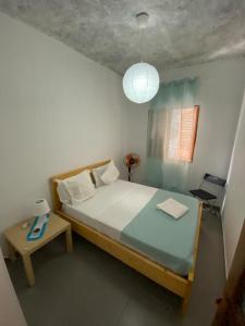 a bedroom with a large bed and a table at Pousada Cantinho de Preta in Seladinha