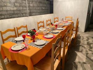 a long wooden table with chairs and food on it at Pousada Cantinho de Preta in Seladinha