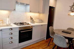 a kitchen with a stove and a table with chairs at Riverside House Lancaster - 2 bedroom house in Lancaster