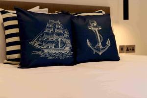 a bed with two pillows with a ship and an anchor at Riverside House Lancaster - 2 bedroom house in Lancaster