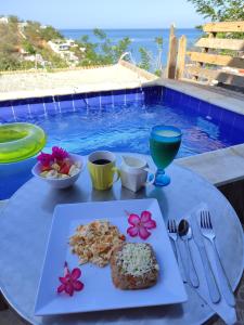 a table with a plate of food next to a pool at Tayrona Colors Hostel in Taganga