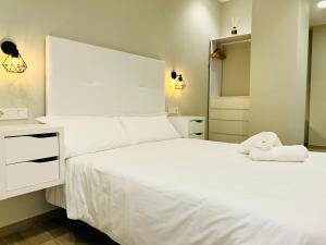 a bedroom with a large white bed and a mirror at RIBERA HOME 2 in Córdoba
