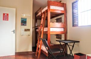 a bunk bed in a room with a table and a chair at Ubatuba Wild Hostel in Ubatuba