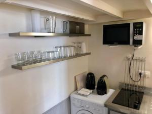 a small kitchen with a microwave and a dishwasher at Pavillon Marais in Paris