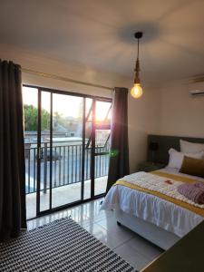 um quarto com uma cama e uma varanda em G’s Self Catering Apartments em Cidade do Cabo
