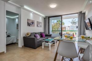 ein Wohnzimmer mit einem Sofa und einem Tisch in der Unterkunft Precioso apartamento en el centro de Las Américas a 100 metros de la playa in Playa de las Americas