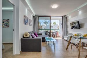 een woonkamer met een bank en een tafel bij Precioso apartamento en el centro de Las Américas a 100 metros de la playa in Playa de las Americas