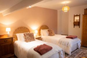 a bedroom with two beds with white sheets at Gardener's Cottage in Lancaster