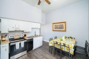eine Küche mit weißen Schränken und einem Tisch mit einem gelben Tischtuch in der Unterkunft ROKU TVs - Washer & Dryer - QueenBeds - GroupStay in Pittsburgh