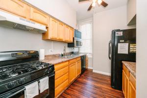 a kitchen with wooden cabinets and a black refrigerator at Pittsburgh's Sports Suite- FREE driveway Parking in Pittsburgh