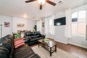 a living room with a leather couch and a ceiling fan at Off-Street Parking - Washer & Dryer - GroupStay in Pittsburgh