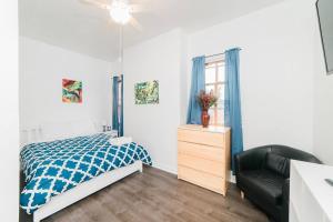 a bedroom with a bed and a chair and a window at Off-Street Parking - Washer & Dryer - GroupStay in Pittsburgh
