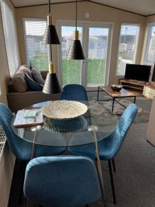uma sala de estar com uma mesa e cadeiras azuis em Playa la Casa em Lossiemouth