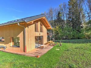 une cabine en bois avec une terrasse dans un champ dans l'établissement Chalet Neuf à Morzine : 4 pers, 75m², Terrasse, Proche Centre, Wifi, Parking - FR-1-524-113, à Morzine
